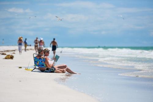 two children sitting in a chair on the beach at Living the Dream in Siesta Key