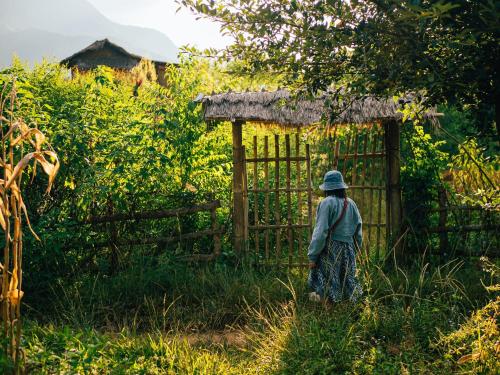 a woman is standing in front of a gate at Imani Eco Sky Lodge Ngoc Chien in Nam San