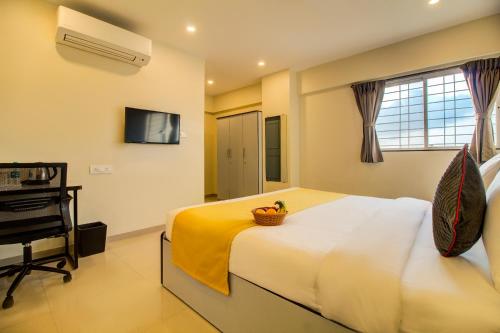 sypialnia z łóżkiem i koszem owoców w obiekcie Housemate Hotel w mieście Pune