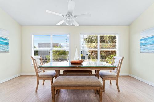 a dining room with a table and chairs and a ceiling fan at Living the Dream By Beachside Management in Siesta Key