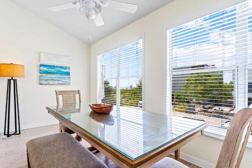 a dining room with a glass table and chairs at Living the Dream By Beachside Management in Siesta Key