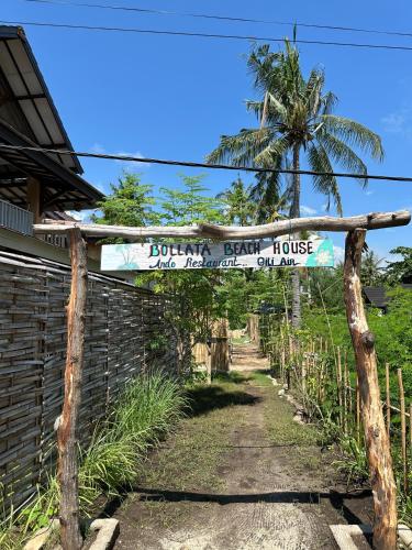 a sign for a house in front of a fence at Bollata beach house in Gili Air