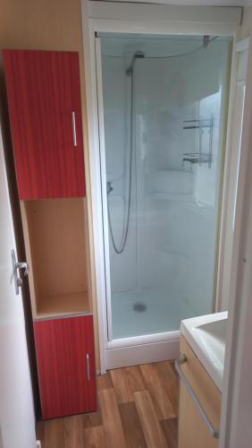 y baño con ducha y armario rojo. en Bungalow T3 Renata en Burinhosa