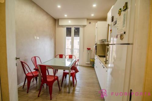 een keuken met een tafel en stoelen en een koelkast bij Residenza Gramsci 13 in Parma