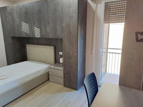een slaapkamer met een bed, een bureau en een raam bij Residenza Gramsci 13 in Parma