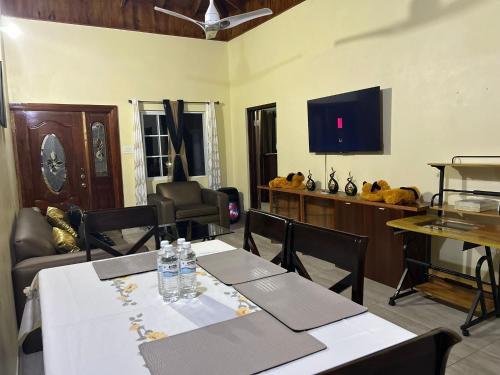 a dining room with two tables and a tv at White House by White River in Ocho Rios
