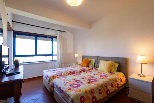 a bedroom with a bed and a desk and a window at Casa do Sol by AcasaDasCasas in Ericeira