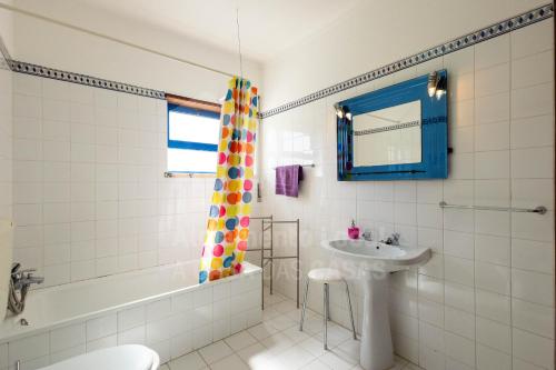 a bathroom with a tub and a sink and a toilet at Casa do Sol by AcasaDasCasas in Ericeira