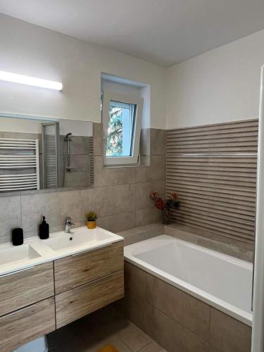 a bathroom with a tub and a sink at ADA Apartman Sopron in Sopron