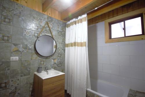 a bathroom with a shower curtain and a sink at Casa Neltume Huilo Huilo in Neltume