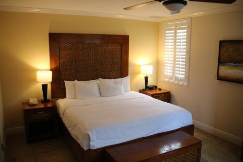 a bedroom with a large bed with two night stands at Divi One Bedroom in Palm-Eagle Beach