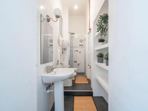 Un baño blanco con lavabo y ducha. en Nice apartment in Milan Porta Venezia Duomo, en Milán