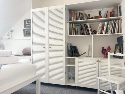 um quarto com uma prateleira de livros brancos com livros em Charming Two Bed house in Central Penzance em Penzance