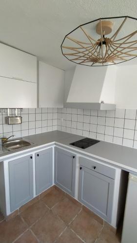 Il comprend une cuisine avec des placards blancs et un ventilateur de plafond. dans l'établissement Appartement Vue Mer Pointe Rouge, 50m plage, à Marseille