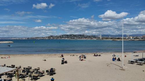 un groupe de personnes assises sur une plage dans l'établissement Appartement Vue Mer Pointe Rouge, 50m plage, à Marseille
