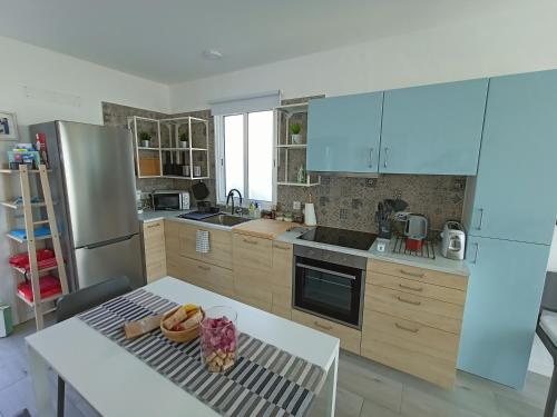 a kitchen with wooden cabinets and a table and a refrigerator at ALDABRA - CASA VACANZE EM PORTO SANTO in Porto Santo