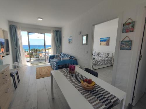 a living room with a table and a living room with the ocean at ALDABRA - CASA VACANZE EM PORTO SANTO in Porto Santo