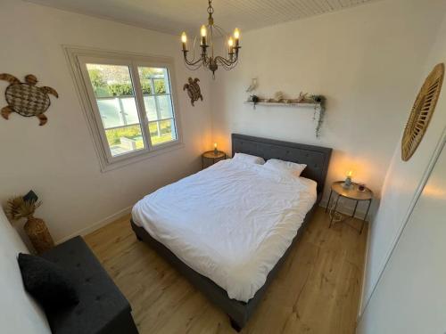 1 dormitorio con 1 cama y 2 mesas con lámparas en Maison cosy 750m de la plage, en Longeville-sur-Mer