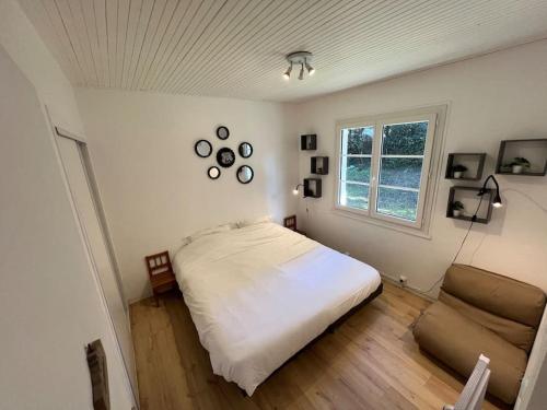 1 dormitorio con cama blanca y sofá en Maison cosy 750m de la plage, en Longeville-sur-Mer
