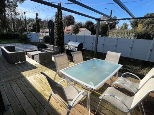 un patio con mesa, sillas y parrilla en Maison cosy 750m de la plage, en Longeville-sur-Mer