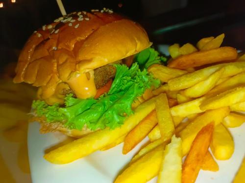 a hamburger and french fries on a plate at Zhaya's Beach & Cottages in El Nido