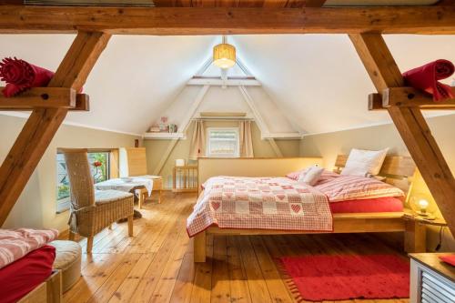 a attic bedroom with a bed and a vaulted ceiling at Chalet Kunterbunt in Langenwetzendorf