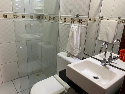 a bathroom with a sink and a toilet and a shower at Mar Y Suites in Cabo Frio