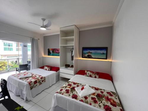 a bedroom with two beds and a window at Mar Y Suites in Cabo Frio