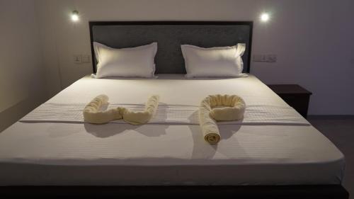 Una cama con dos toallas de ganchillo. en The White Pillow en Arugam Bay