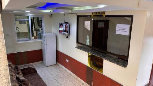 een wachtkamer met een koelkast in een gebouw bij White Star Hotel in Nairobi