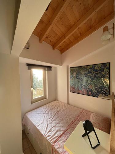 ein Schlafzimmer mit Bett, Schreibtisch und Fenster in der Unterkunft La casa tra gli alberi e il cottage in Fiskardo