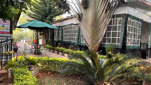 a green building with a table and an umbrella at White Star Hotel in Nairobi