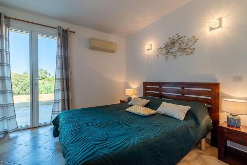 - une chambre avec un lit vert et une grande fenêtre dans l'établissement Duplex vue mer - Ile Rousse, à LʼÎle-Rousse