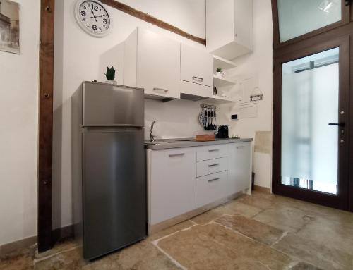 a kitchen with a refrigerator and a clock on the wall at La perla casa vacanze in Barletta