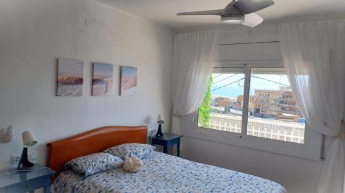 sypialnia z łóżkiem i dużym oknem w obiekcie Canet playa y centro w mieście Canet de Mar