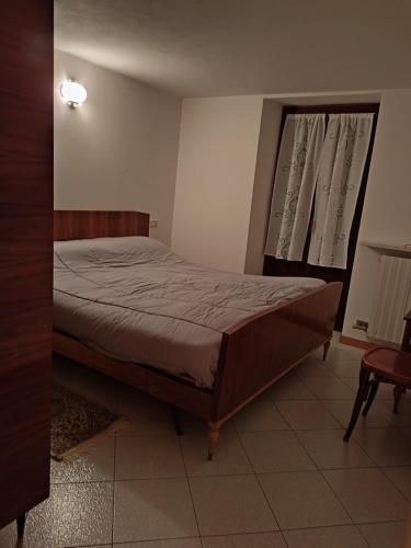a bedroom with a bed and a window at Appartamento centro storico in Ornica
