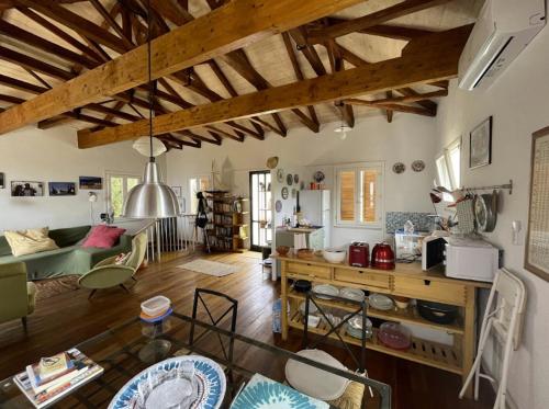 ein großes Wohnzimmer mit Holzdecken und ein Wohnzimmer in der Unterkunft La casa tra gli alberi e il cottage in Fiskardo