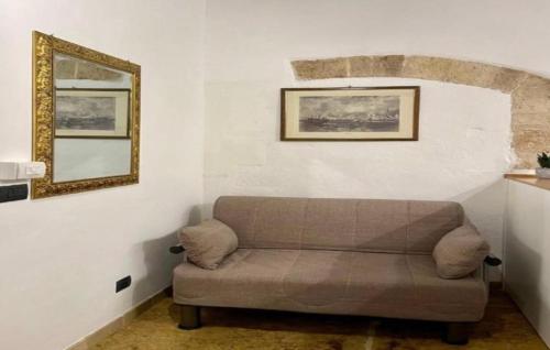 sala de estar con sofá y espejo en La perla casa vacanze en Barletta