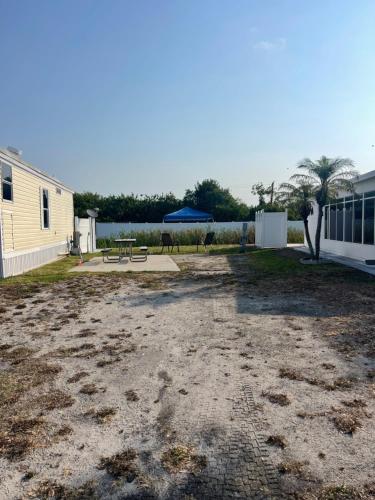 a yard with a picnic table and a building at RV SITE FOR RENT BY GLAMPERS CAMP 30AMP FULL HOOKUP in Port Charlotte