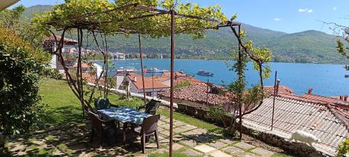 a table and chairs on a patio with a view of a lake at Rosemary Apartment in Ohrid