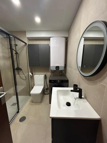 a bathroom with a sink and a toilet and a mirror at la casa de Adela - Cala lanuza in El Campello