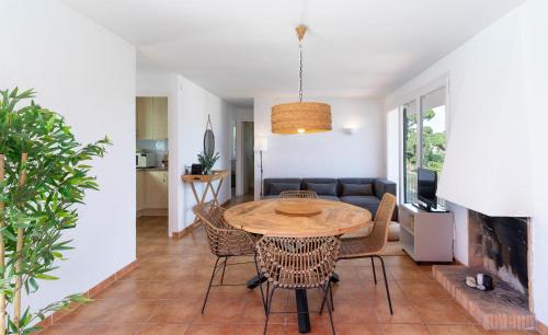 a dining room and living room with a table and chairs at Apartamentos CASA MAREA Calella Palafrugell con Parking in Calella de Palafrugell