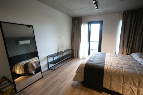 1 dormitorio con 1 cama grande y espejo en UNDICI By OWN Republica de la Boca en Buenos Aires