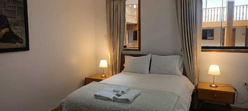 een slaapkamer met een bed met handdoeken erop bij Hotel Aural in Cajamarca