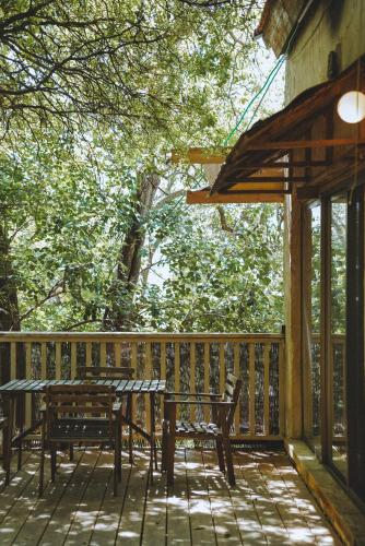 a wooden deck with a table and benches on it at THE HOUSE IN THE OAKS הבית באלונים in Amirim