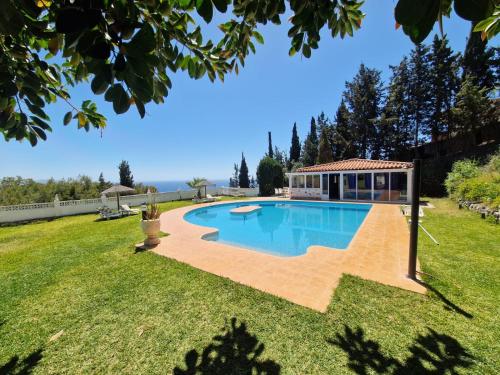 a swimming pool in a yard with a gazebo at las flores in Almuñécar