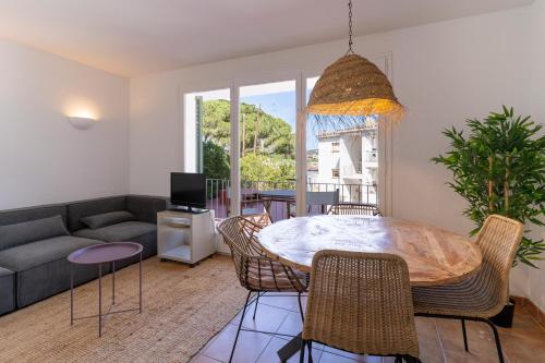 a living room with a table and chairs at Apartamentos CASA MAREA Calella Palafrugell con Parking in Calella de Palafrugell