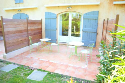 une terrasse avec des tables et des chaises en face d'une maison dans l'établissement Appartement 9 en Duplex- LES SUITES DE ROBINSON - Résidence avec piscine en bord de Siagne, à Mandelieu-La-Napoule, à Mandelieu-la-Napoule