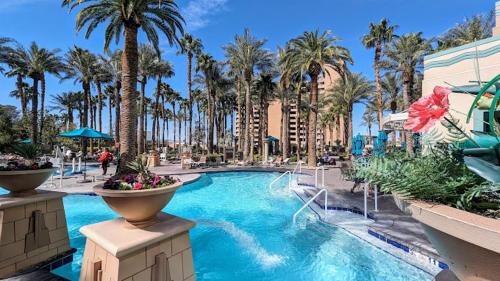 una piscina en un complejo con palmeras en Hilton Grand Vacation Club The Boulevard, en Las Vegas