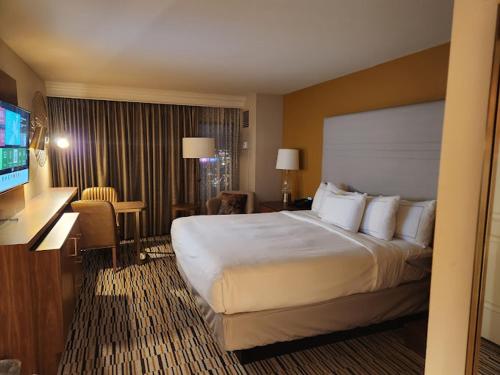 ein Hotelzimmer mit einem großen Bett und einem TV in der Unterkunft Hilton Grand Vacation Club The Boulevard in Las Vegas
